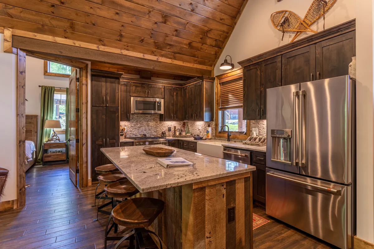 A well-lit kitchen space dominated by a large kitchen island, surrounded by ample cabinets and modern appliances. Natural light streams in through the windows, illuminating the ideal spot for meal prep, entertaining, and casual family interactions.